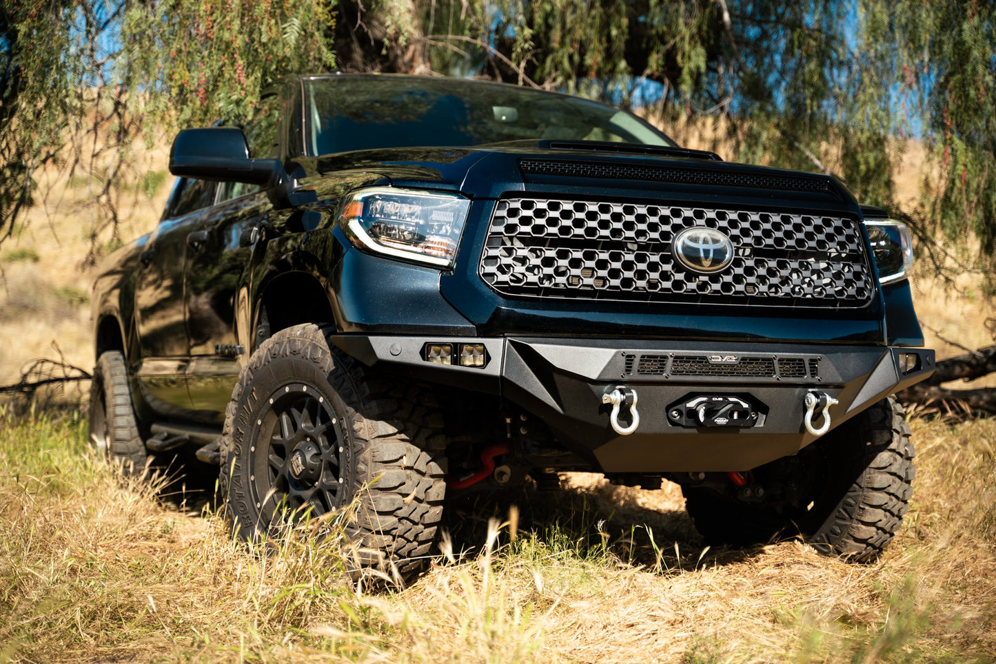 Winch front bumper mounted to a Tundra in a field.